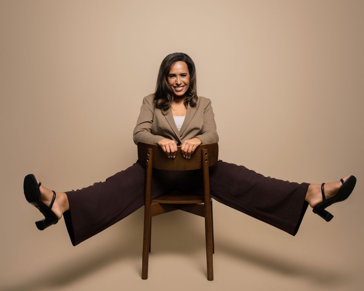 Camille (Cami) Boudreaux, Fix Your Picker relationship and life coach for women, laughing on a chair with her legs kicked out wide